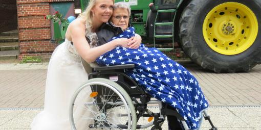 Braut und Brautmutter, die im Rollstuhl unter einer Sternendecke sitzt.