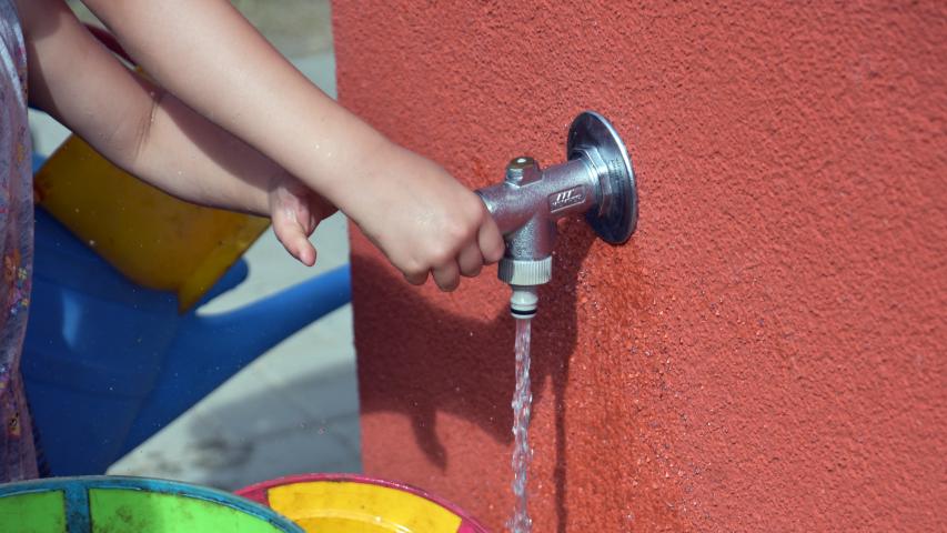 Kinderhand und Wasserhahn