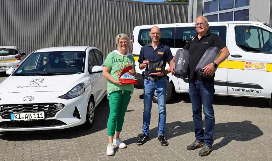 Übergabe der Schlafsäcke an Wolfgang und Astrid Baasch durch Wolfgang Mainz (Mitte), Geschäftsführer des ASB Kiel. Foto: Martin Geist