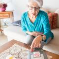 Eine ältere Frau mit ASB-Hausnotruf-Gerät